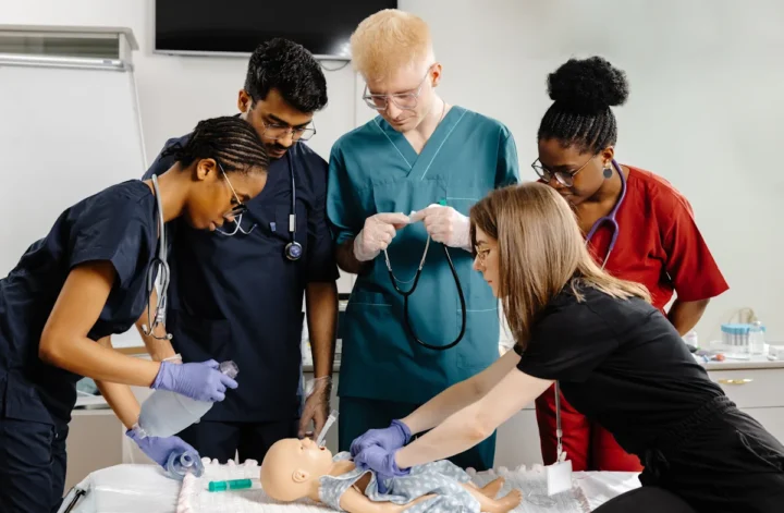 Un groupe de personne qui apprend à prendre en charge un nouveau-né avec un mannequin