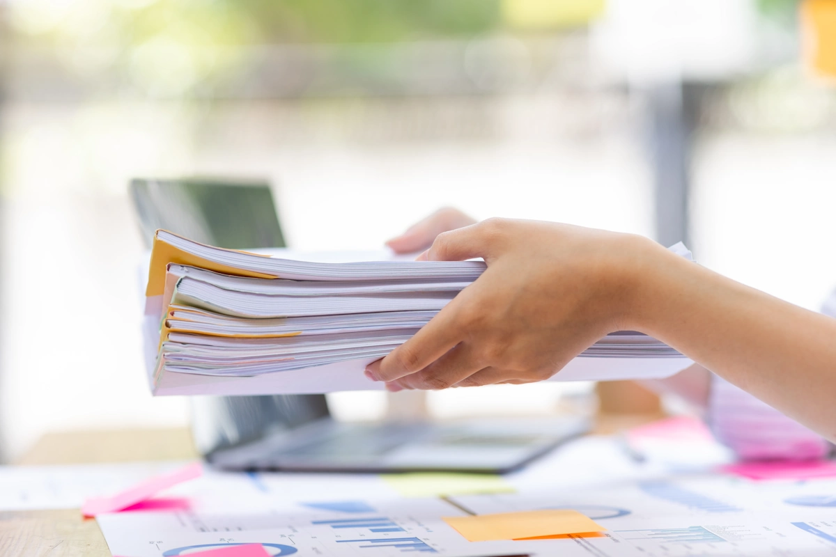 Une main qui tient des documents administratifs d'entreprise 